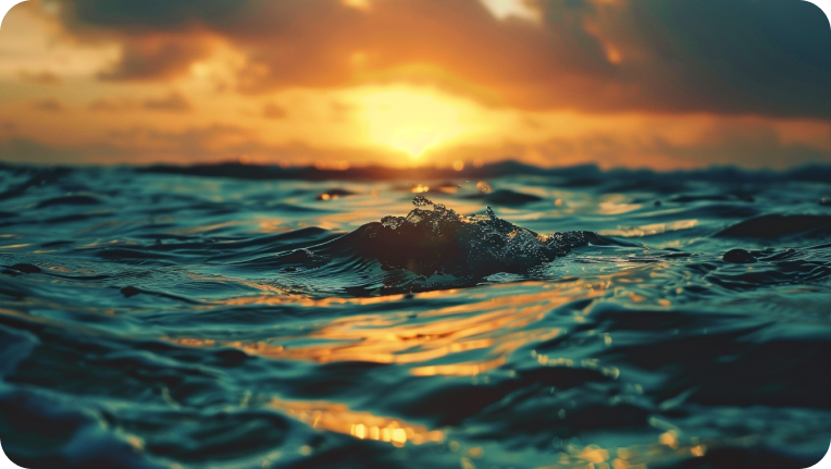 A photo of the sun setting out on the water.